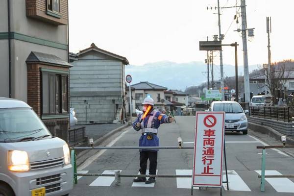 2月14日，日本福岛县桑折町一处因地震受损的房屋附近道路被封锁。新华社记者杜潇逸摄
