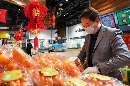 春节期间，某超市工作人员在码放水果。新华社记者任超摄