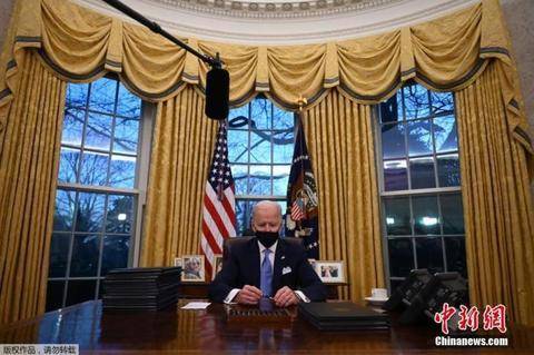 图为美国总统拜登在华盛顿白宫椭圆形办公室签署行政命令。