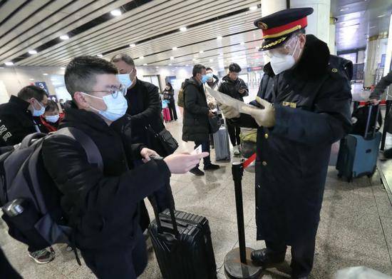 北京西站，铁路工作人员正在查验出站旅客核酸检测证明。新京报记者王贵彬摄