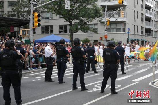 资料图：同性恋骄傲大游行在纽约举行，纽约也提升了安保工作。图为游行队伍旁执勤的纽约警察。中新社记者马德林摄