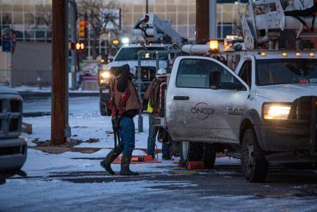 2021年2月18日，工人们在美国得克萨斯州敖德萨准备修理电线杆。新华社图