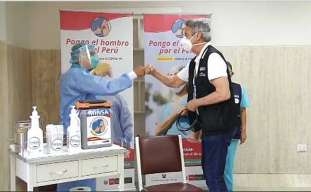 秘鲁总统接种后与医务人员击拳（社交媒体）