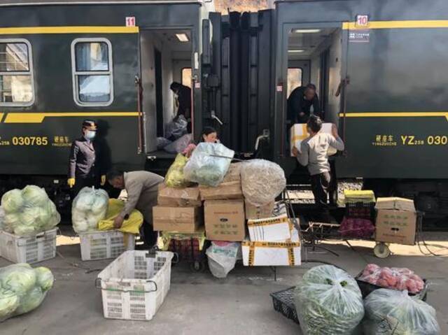 ▲2月26日，冕宁站，彝族老乡正在往5634次列车上搬运批发的蔬菜。新京报记者韩沁珂摄