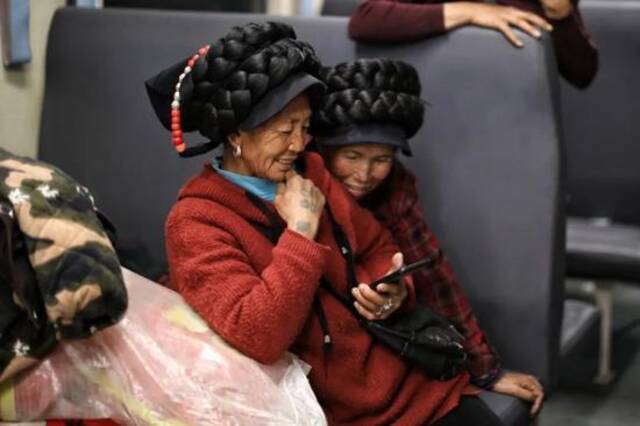▲2月26日，5634次列车上的彝族乘客在用手机看短视频。新京报记者王嘉宁摄