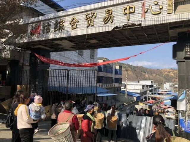 ▲2月26日，泸沽综合贸易中心门前，乘5633次列车前来的彝族老乡排队进入市场采购。新京报记者韩沁珂摄