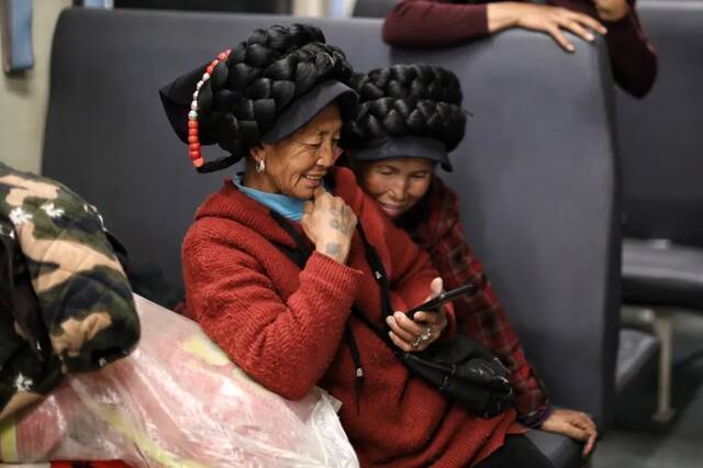  2月26日，5634次列车上的彝族乘客在用手机看短视频。新京报记者王嘉宁摄