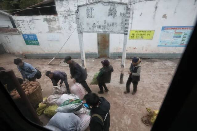  2月27日，5633次列车停靠红峰站，乘客带着货物上车。新京报记者王嘉宁摄