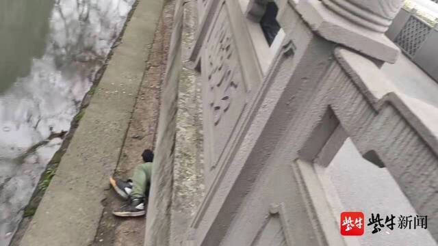 图为男子翻下2米河堤避雨