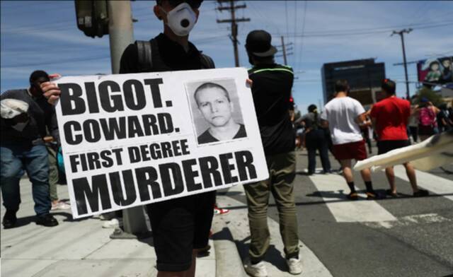 明尼阿波利斯的抗议者举着肖万的照片。图源：国会山报