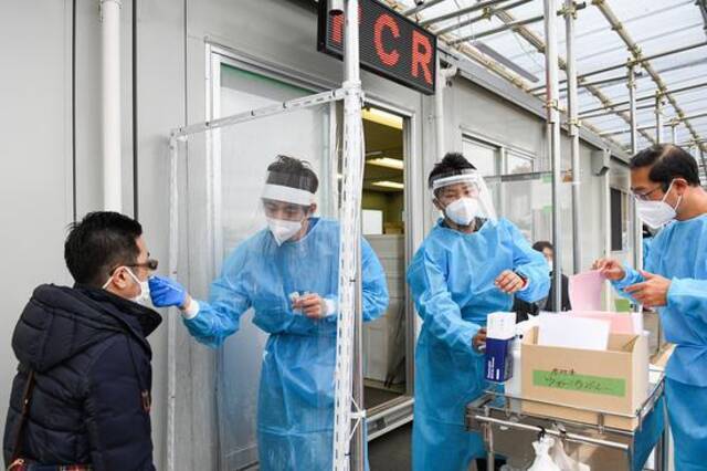 资料图：日本医护人员在给民众做新冠病毒核酸检测