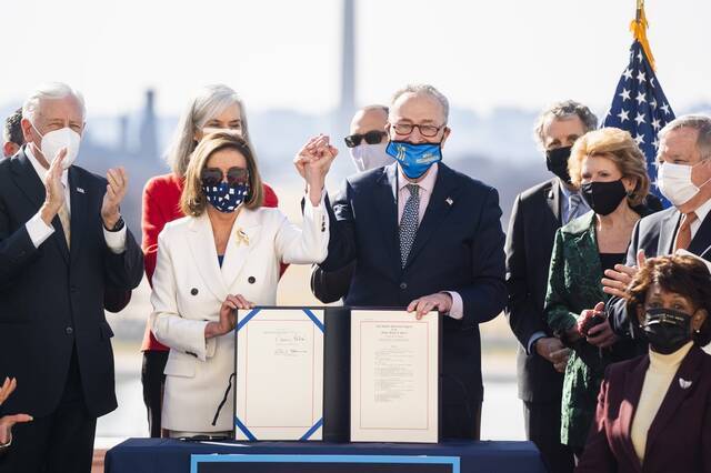 当地时间2021年3月10日，华盛顿，美国众议院以220票赞成、211票反对的结果，投票通过了1.9万亿美元的新冠纾困救助法案，众议院议长佩洛西和美国会参议院多数党领袖、民主党人舒默签署法案。图片来源：澎湃影像