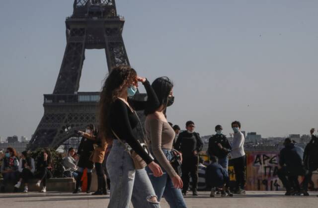 法国巴黎，民众戴着口罩在埃菲尔铁塔附近行走（资料图）