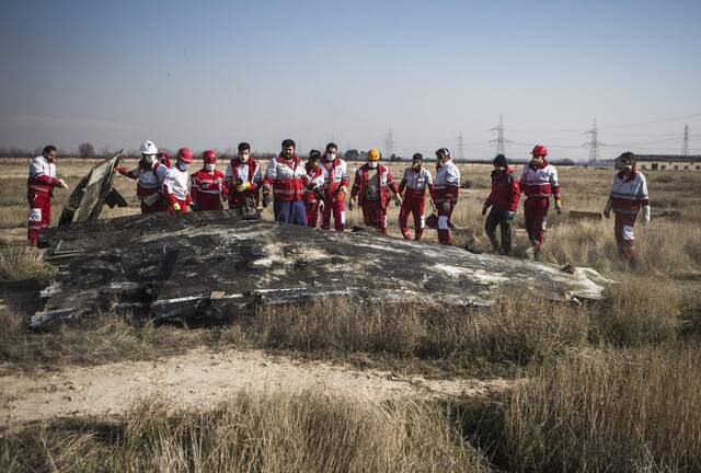 当地时间1月8日，在伊朗德黑兰霍梅尼国际机场附近，救援人员在坠机现场工作。新华社发
