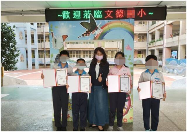 新北板桥文德小学校长李慧美（中）表扬学生参加“首届两岸青少年好家风好家训”征文大赛获得佳绩。图自台媒