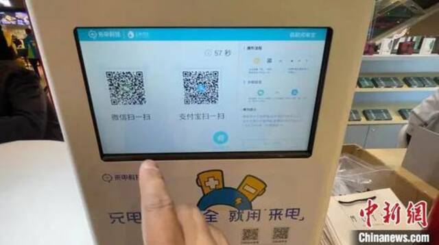 资料图：市民在租借共享充电宝。康玉湛摄
