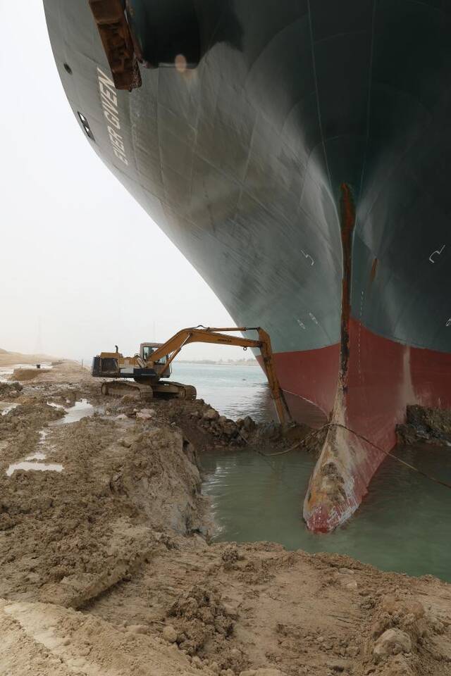 3月25日，工程机械在埃及苏伊士运河上重型货船搁浅的现场进行作业。新华社发（苏伊士运河管理局供图）
