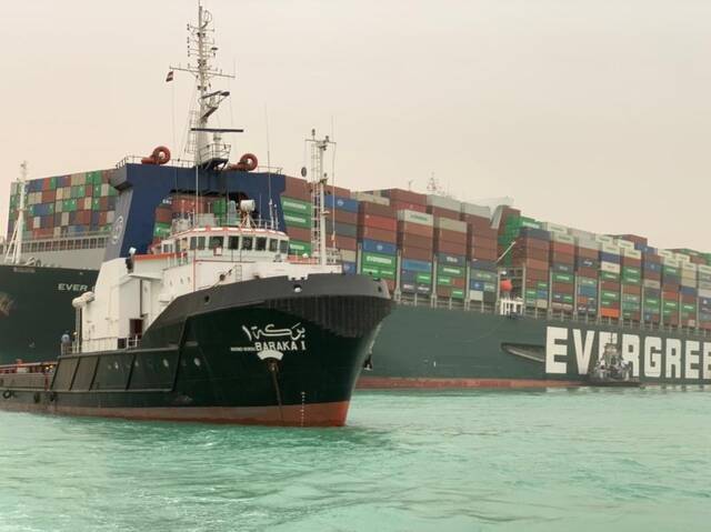 3月24日，一艘拖船在埃及苏伊士运河重型货船搁浅的水域作业。新华社发