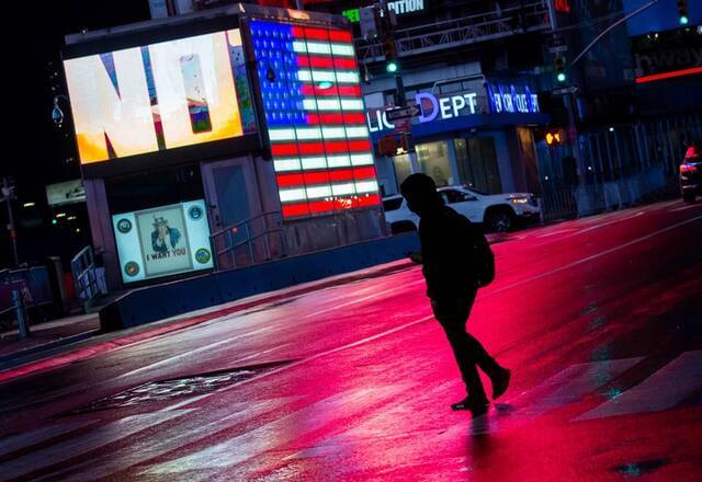3月24日，行人在美国纽约时报广场过马路。新华社发（郭克摄）