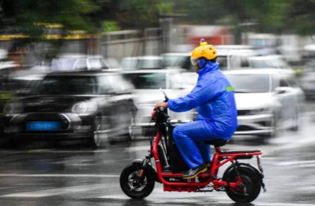 一名外卖员冒雨骑行送餐许畅摄