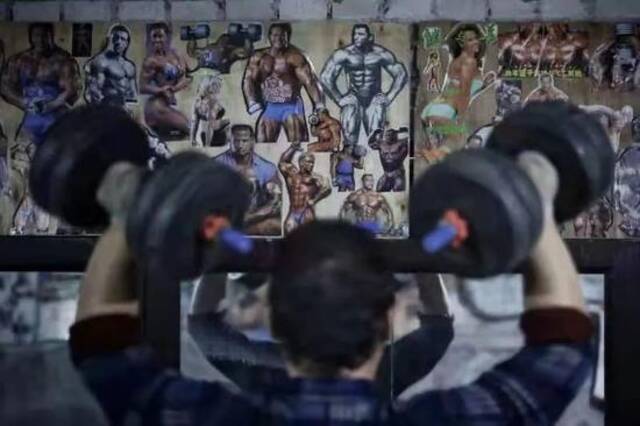 健身房的墙上贴着各种健美图片