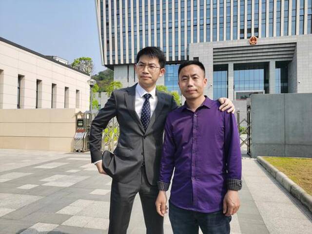 3月26日，庭审结束后，申军良与代理律师刘长在法院门口。澎湃新闻记者朱远祥摄