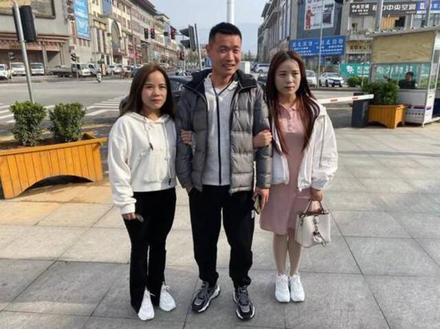  3月27日，张丽和程珂珂挽着张丽的表哥拍照。新京报记者乔迟摄