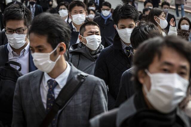 资料图：街头佩戴口罩的日本民众