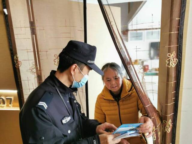 ▲民警何刚给社区居民宣传反诈信息