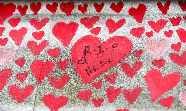 ↑这是3月31日在伦敦拍摄的国家新冠纪念墙上红色的心和悼念的留言。