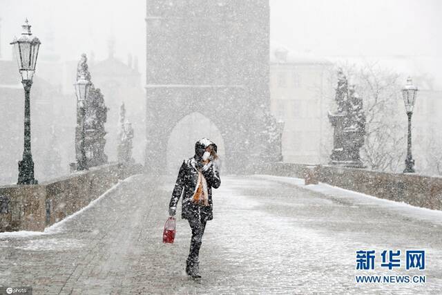 当地时间4月6日，捷克布拉格，民众冒着暴风雪，走过查理大桥。（图片来源：东方IC）