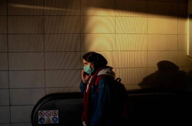 1月23日，一名佩戴口罩的女子走出伊朗首都德黑兰的一处地铁站。新华社发（艾哈迈德·哈拉比萨斯摄）