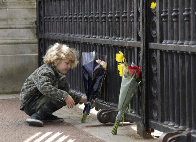 英国民众在白金汉宫外献花