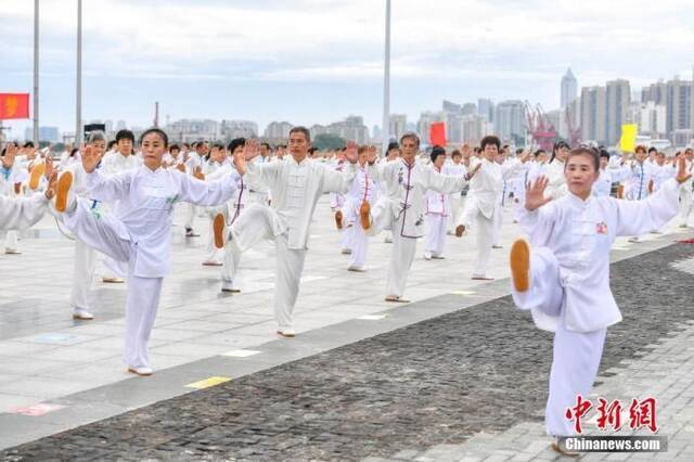 资料图：太极爱好者一起在海边晨练打太极拳。中新社记者骆云飞摄