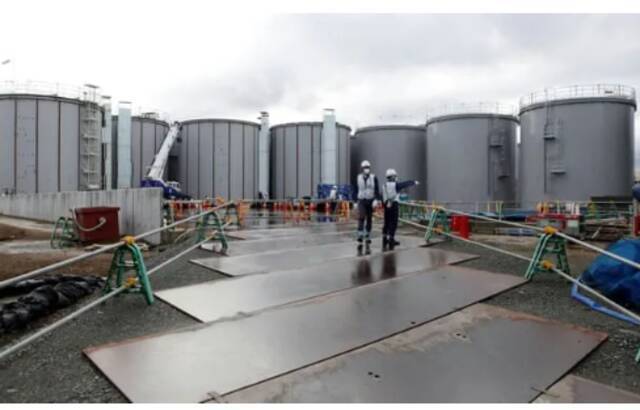 日本福岛第一核电站的工作人员站在核废水储存罐附近。来源：路透社