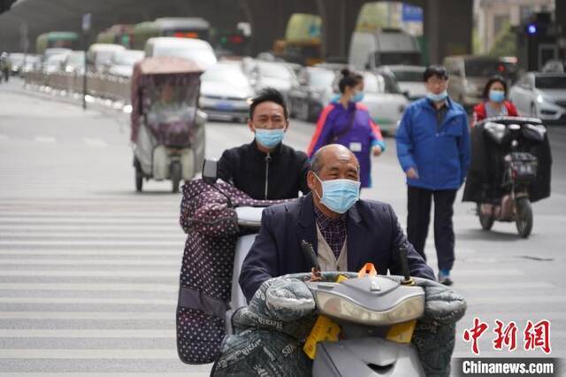 浮尘天气，郑州市民戴口罩出行。韩章云摄