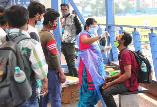 4月11日，一名男子在印度班加罗尔的一个公交站接受新冠病毒检测取样。（新华社发）