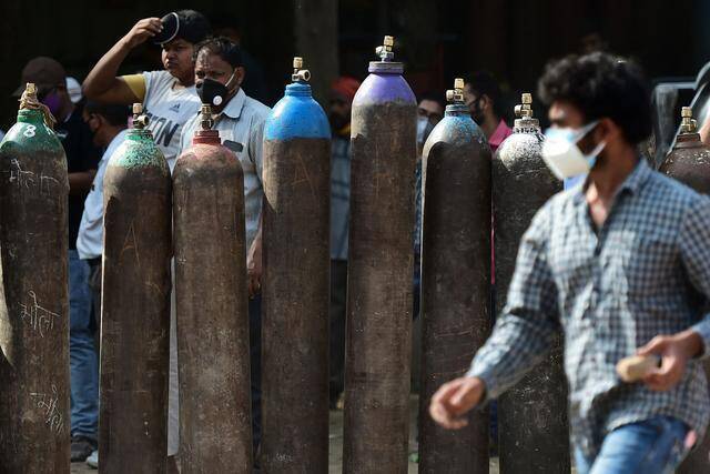↑4月24日，人们在印度安拉阿巴德等待填充氧气罐新华社/法新