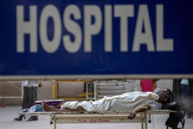 △4月23日，印度新德里一名确诊新冠肺炎的患者正在等待住院床位。图片来源：路透社