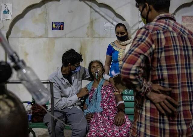 24日，一名感染新冠肺炎的妇女在寺庙吸氧。图源：时代周刊