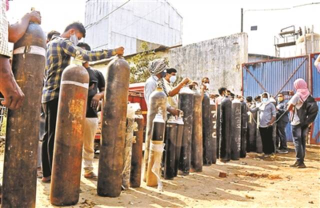 4月27日，人们在印度巴特那等待为氧气罐充氧