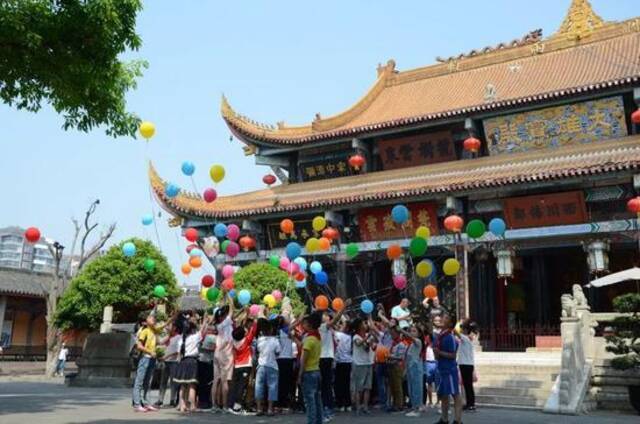 十周岁集体生日会上，手持气球的“罗汉娃”聚在大雄宝殿门口。受访者供图