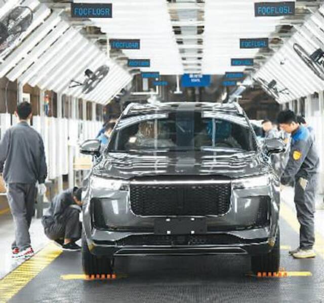 4月25日，理想汽车江苏常州制造基地内的智能化汽车生产线上，工人正在生产装配新能源汽车。夏晨希摄（人民视觉）