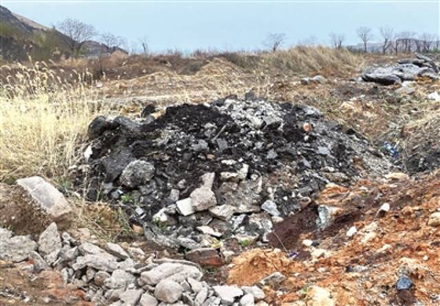 非法建成的排矸场沟壑内倾倒的大量固体废物，污染严重。（生态环境部供图）