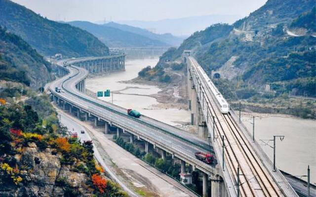 位于嘉陵江四川广元段的明月峡集“古栈道、古驿道、嘉陵江水道、纤夫道、公路、铁路”古今六道于一峡，集中展现了古代、近代、现代交通历史变迁的全过程。图为列车驶过广元嘉陵江特大桥。中新社发曹宁/摄