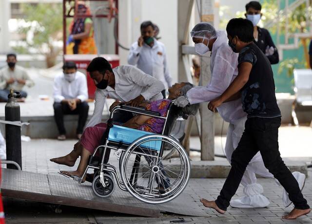 4月30日，一名坐轮椅的新冠患者被送往印度艾哈迈达巴德的一家医院。新华社图