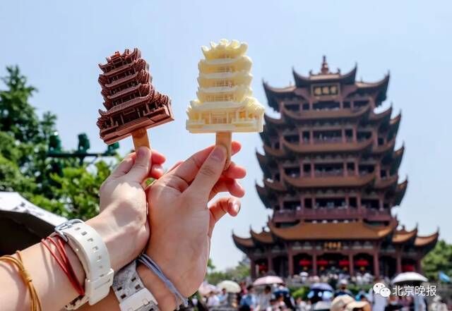 今年5月1日，游客手拿黄鹤楼网红雪糕在黄鹤楼前留影。此款雪糕自武汉黄鹤楼景区推出以来，便成为了不少游客打卡黄鹤楼时的必选品。视觉中国供图