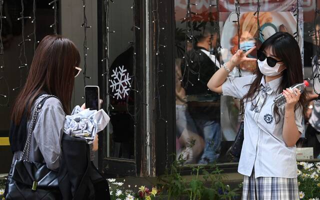 5月3日，南锣鼓巷，游客拍照留念。摄影/新京报记者陶冉