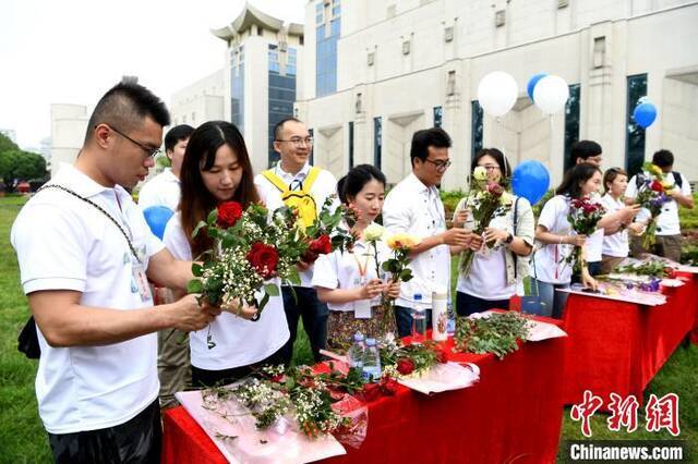 两岸婚姻佳偶一起学插花。王东明摄