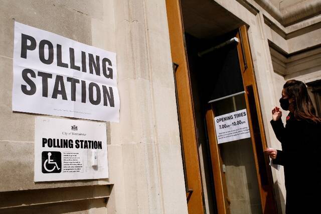 ↑5月6日，一名女子走进英国伦敦一处投票站。新华社发（大卫·克利夫摄）
